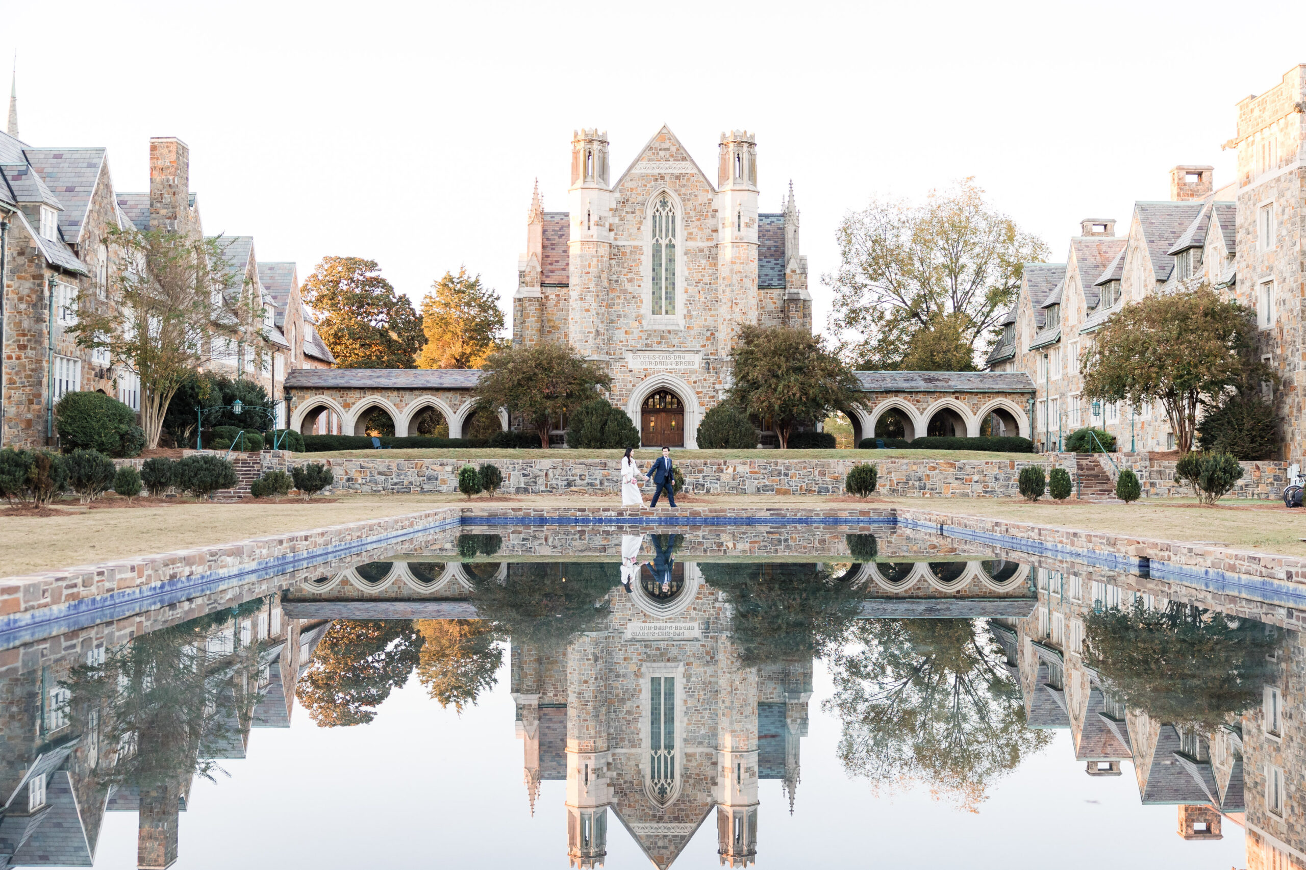 bride and groom walking in front of an old building at berry college