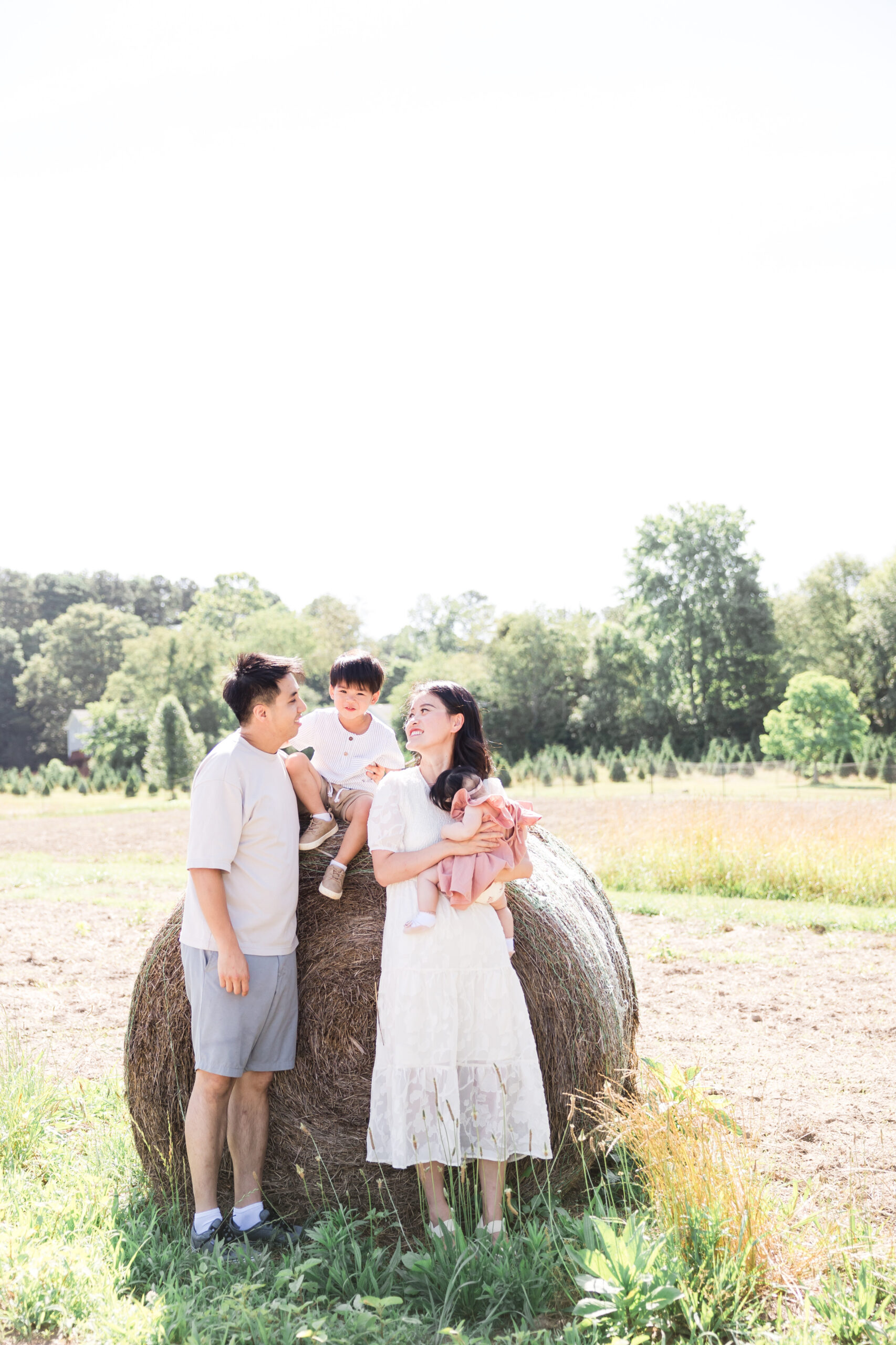 Family session with parents looking at son at open field