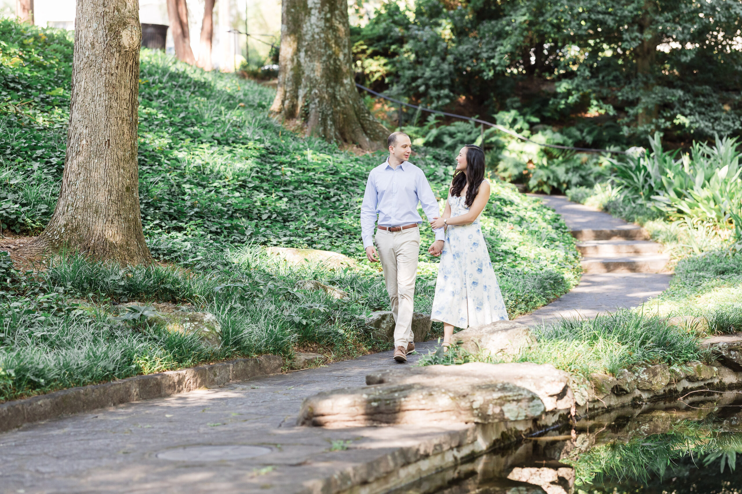 Husband and wife walk arm-in-arm while smiling at each other